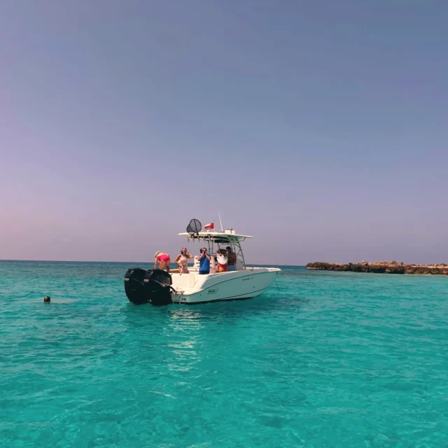 The boat in turquoise water near the island