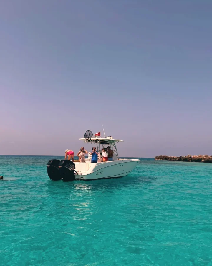 The boat in turquoise water near the island
