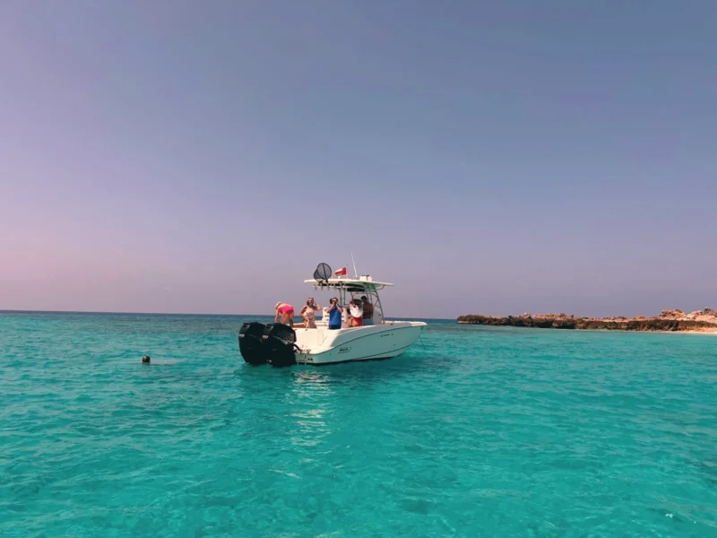 The boat in turquoise water near the island