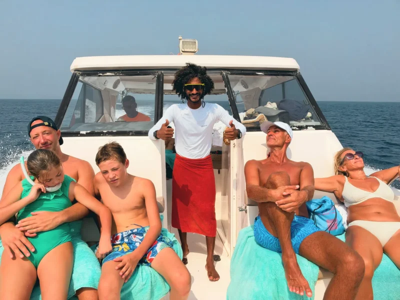 A family relaxing in the sun on the deck of the boat