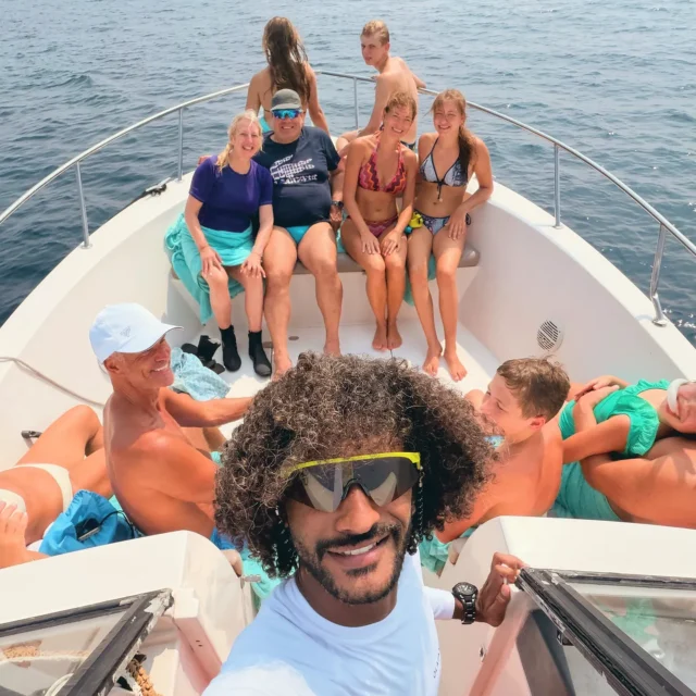 A group selfie on the bow of the boat, open sea behind