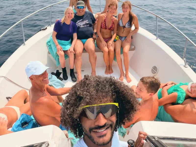 A group selfie on the bow of the boat, open sea behind