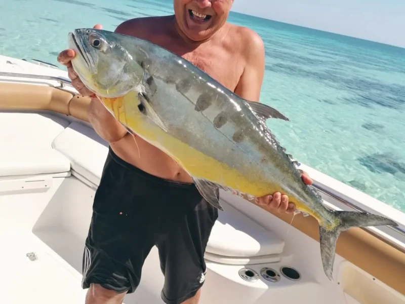 A guest holding up a trevally