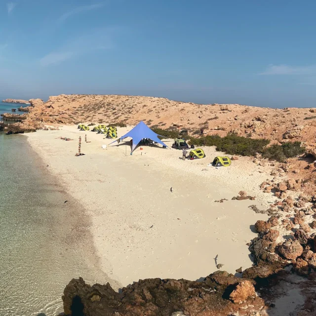 An overnight camp in a sandy cove between rocky headlands