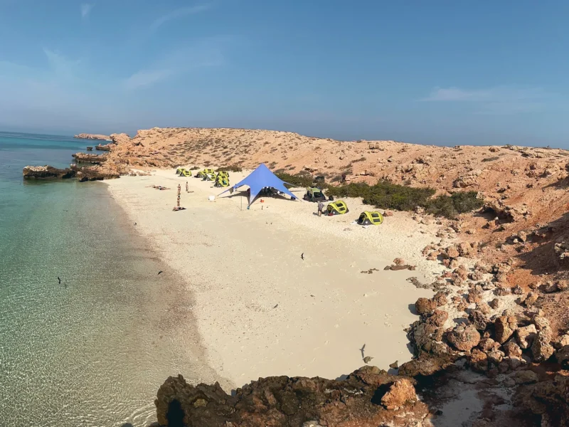 An overnight camp in a sandy cove between rocky headlands