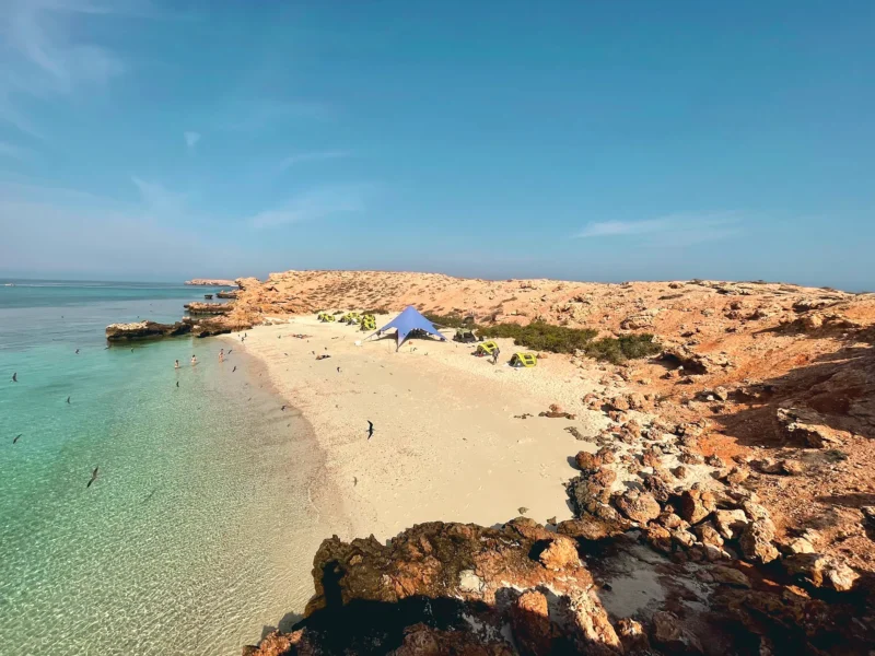 Looking down on the camp from the rocks, above clear shallow water