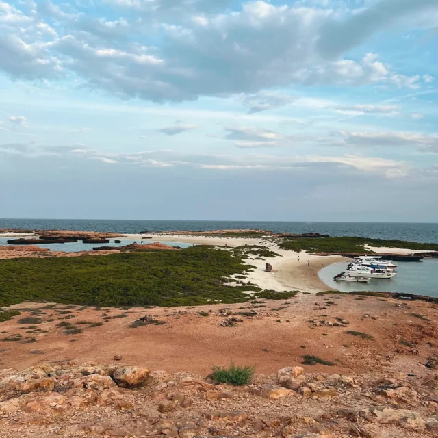 A boat in a lagoon seen from the island above
