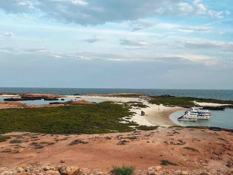 A boat in a lagoon seen from the island above