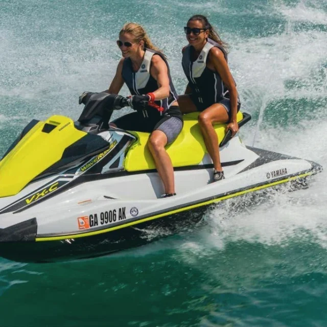 Two riders leaning into a turn on a jet ski