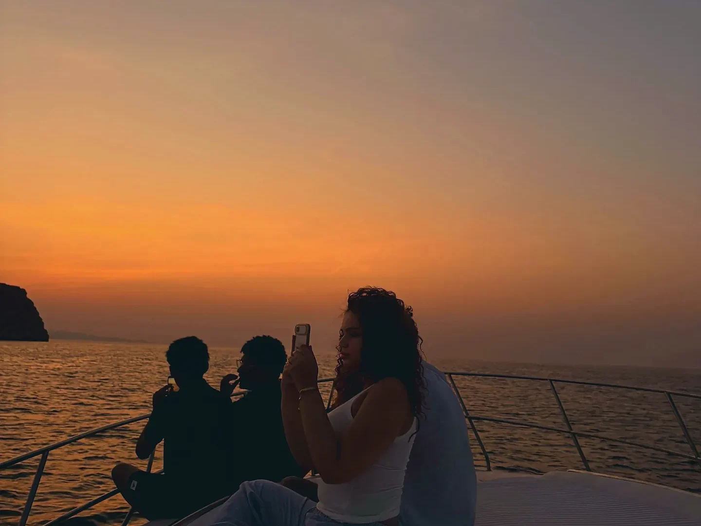Guests on the bow of the boat at sunset