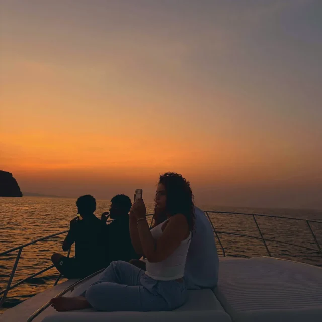 Guests on the bow of the boat at sunset