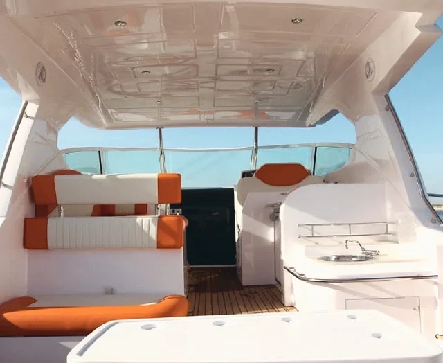 The yacht cockpit: white and orange seating under the hardtop