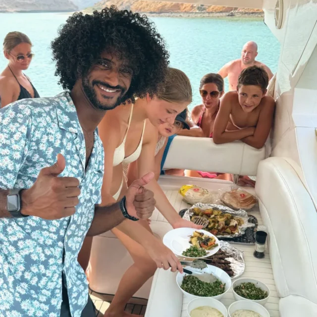 A thumbs-up beside the lunch buffet on the yacht while guests help themselves
