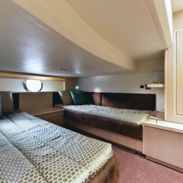 A twin cabin with two single beds and a porthole