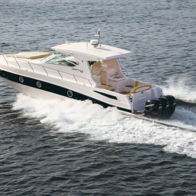 A white motor yacht with a black hull stripe under way