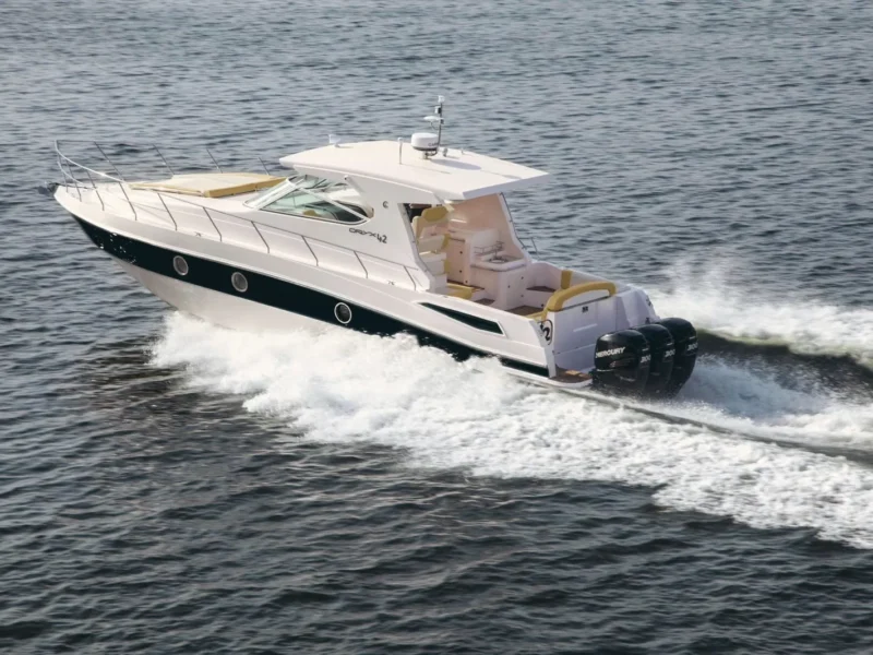 A white motor yacht with a black hull stripe under way