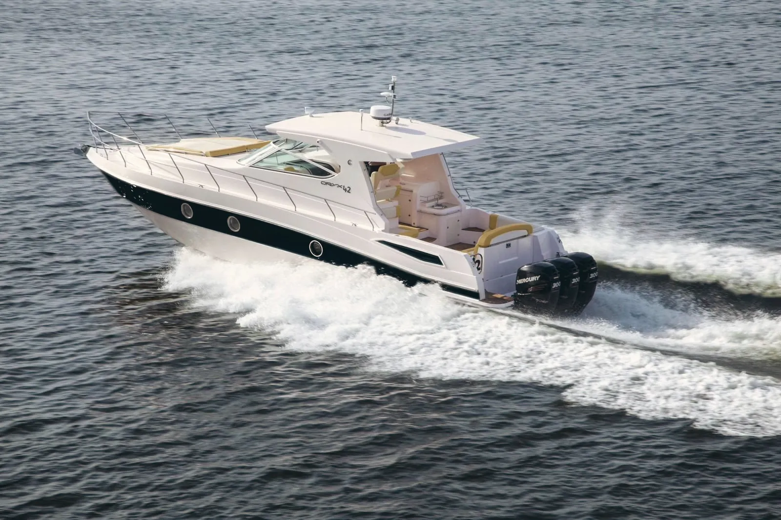 A white motor yacht with a black hull stripe under way